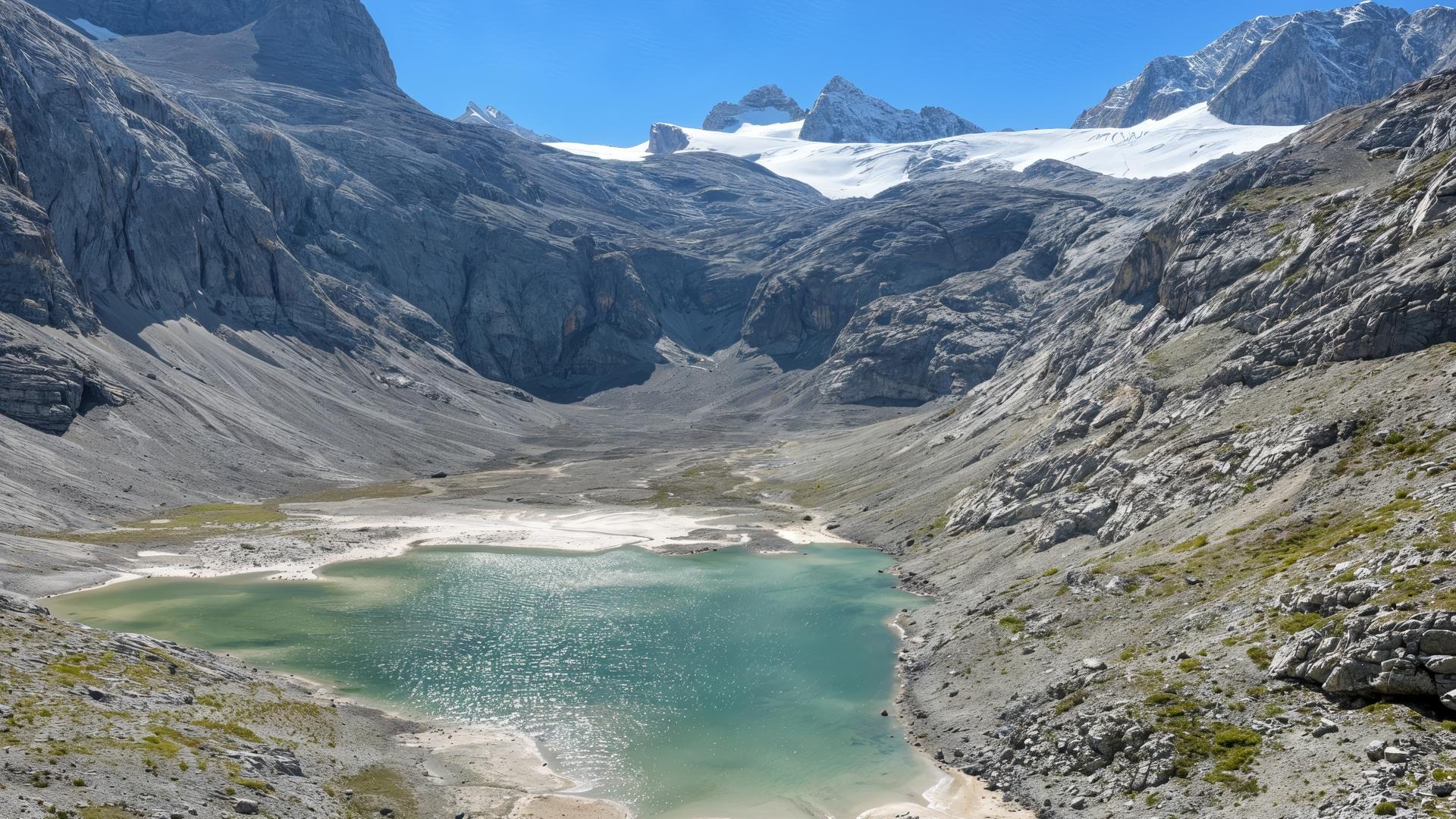 Letzte Reste des unteren Eissees am Dachsteingletscher, umgeben von felsiger Hochgebirgslandschaft unter klarem Himmel.