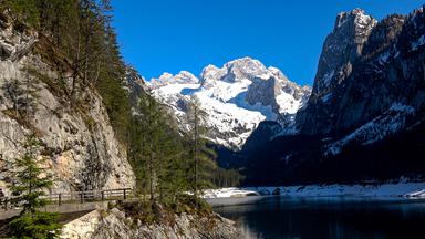 Alpensee gerahmt von schneebedeckten Bergen.