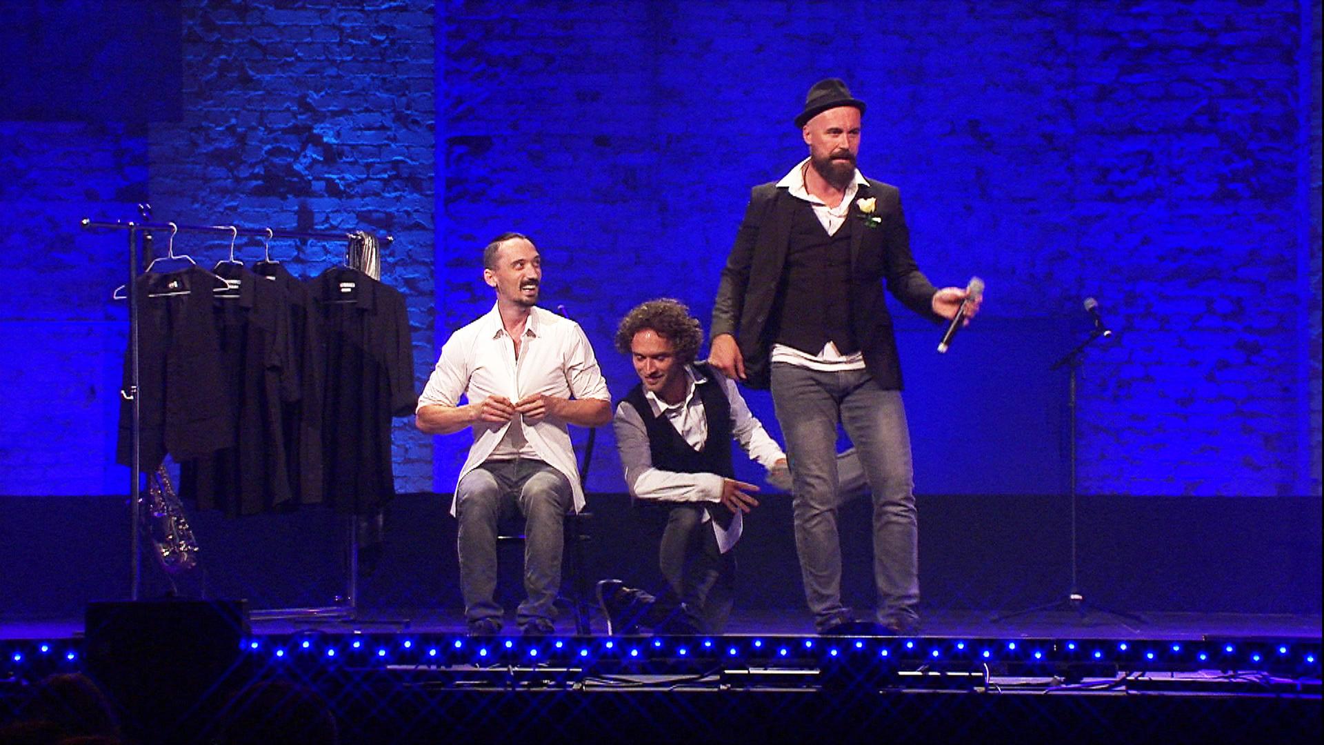 Drei Männer auf einer Bühne.