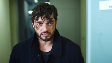 Blutverschmiertes Gesicht eines bärtigen Mannes.