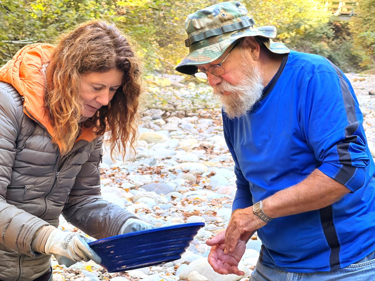Ein Mann und eine Frau schauen in ein blaues Sieb