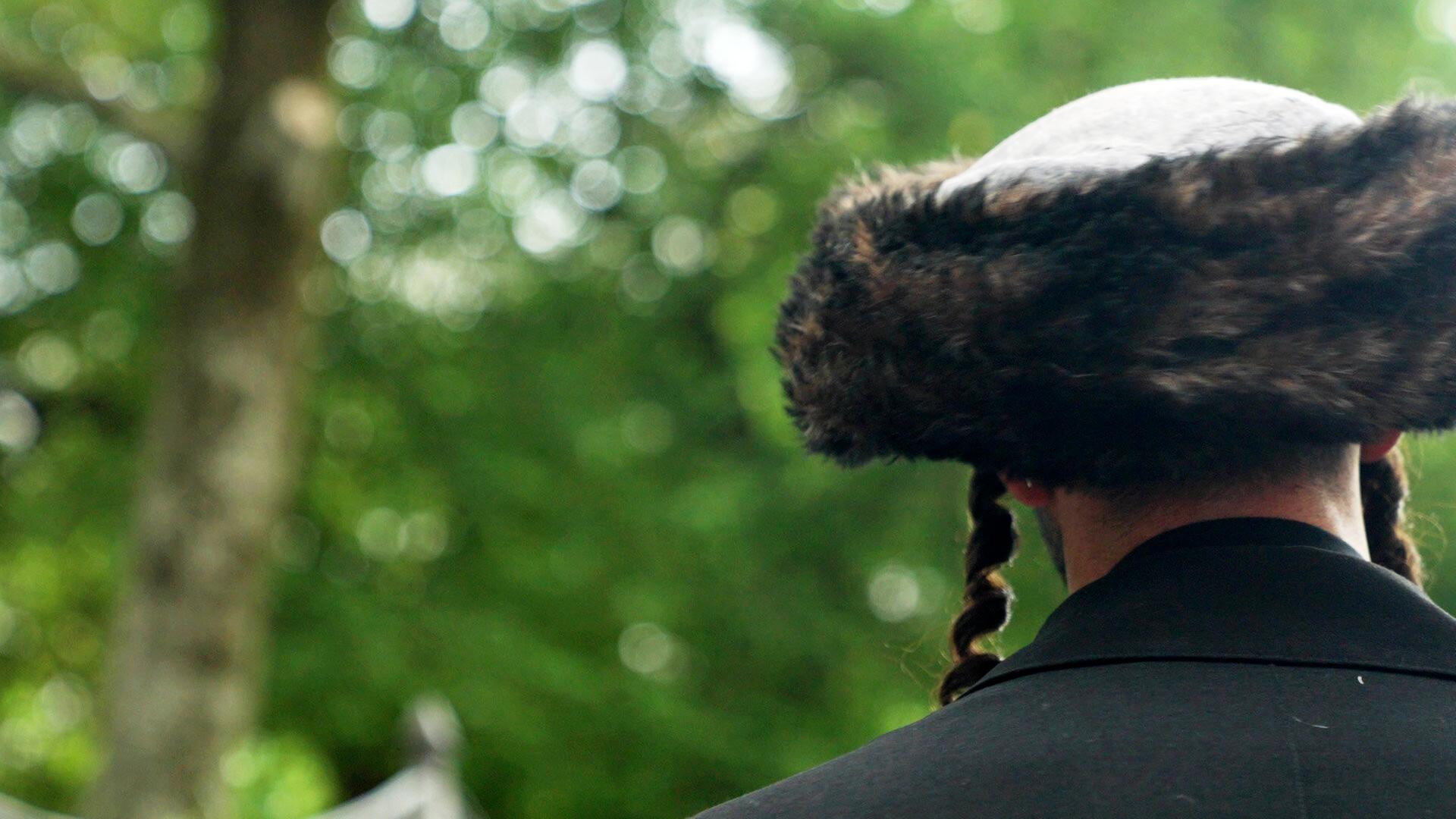 Ein Mann mit traditioneller jüdischer Kopfbedeckung von hinten