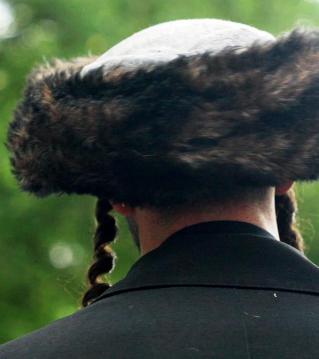 Ein Mann mit traditioneller jüdischer Kopfbedeckung von hinten
