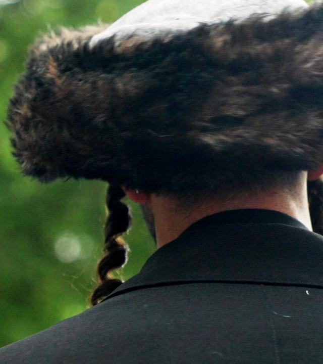 Ein Mann mit traditioneller jüdischer Kopfbedeckung von hinten