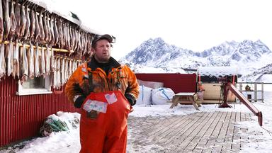Ein Fischer auf einer Insel im norwegischen Eismeer vor seinem Fang.