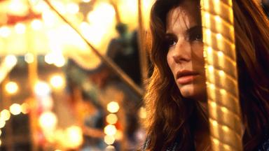 Mit gehetztem Gesichtsausdruck hält sich Angela (Sandra Bullock) auf dem Jahrmarkt an der Stange eines Karussells fest.