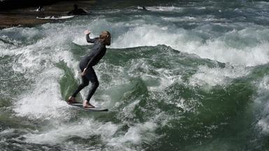 Eine Surferin in den Wellen der Isar.