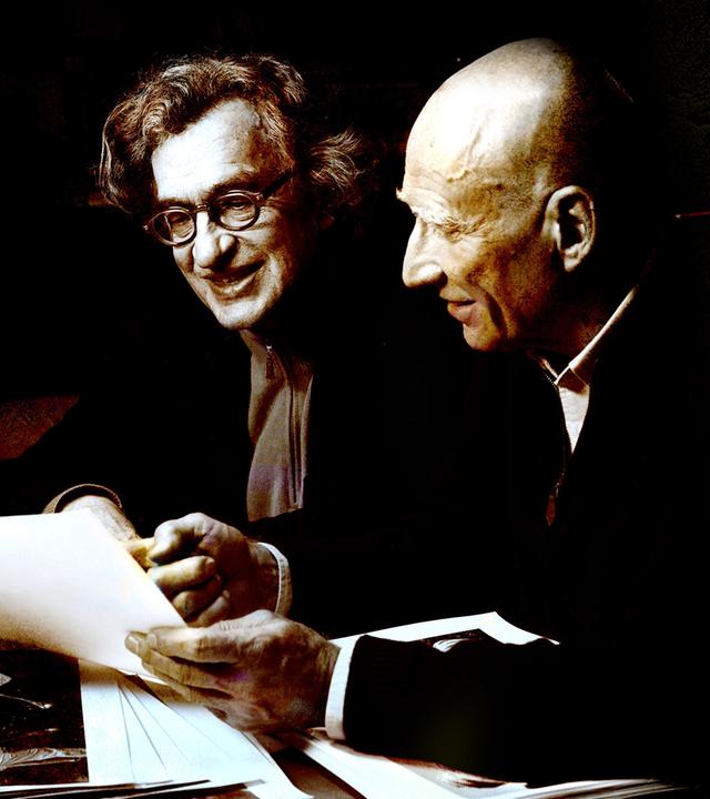 Zwei Männer sitzen nebeneinander und unterhalten sich.