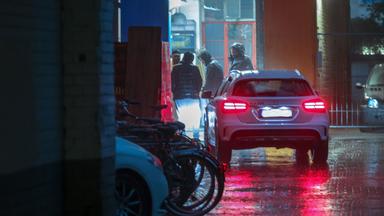 Männer in einer Autowerkstatt stehen im Halbdunkel zusammen