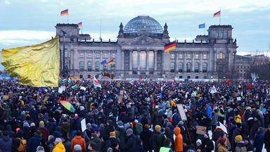 Vor dem Reichstagsgebäude in Berlin demonstrieren zahlreiche Menschen mit Flaggen.