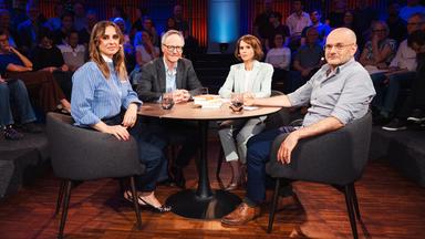 Zwei Frauen und zwei Männer sitzen um einen runden Tisch