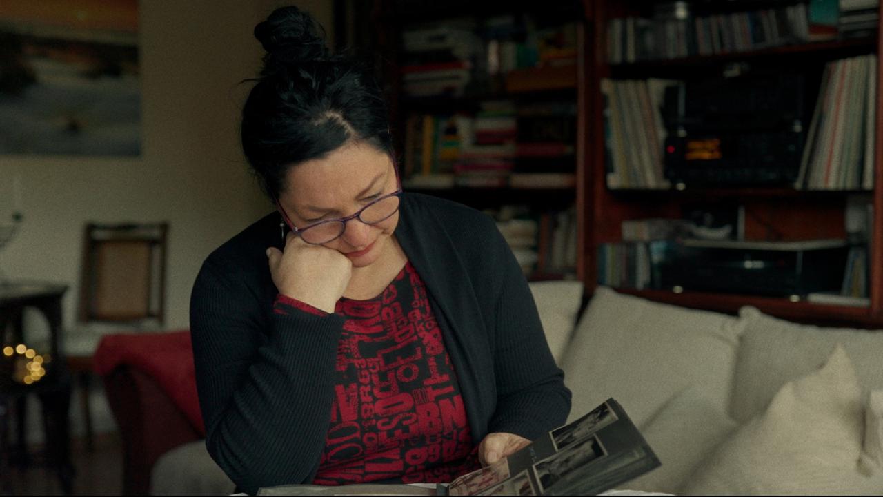 Sitzende Frau blättert durch ein Album.