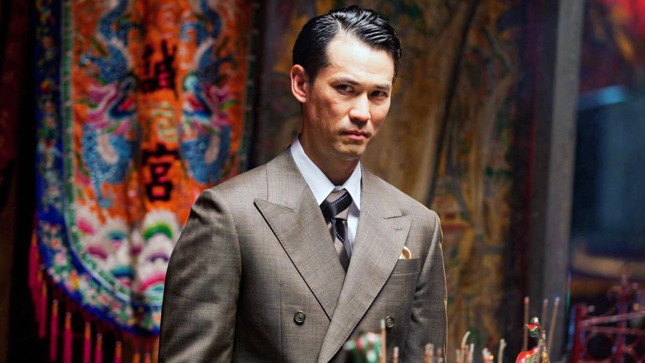 Asiate im Anzug mit skeptischen Blick