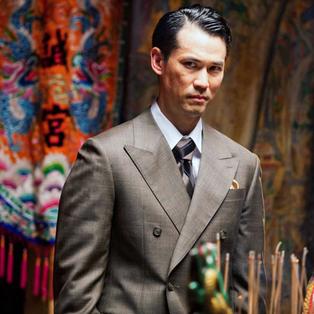 Asiate im Anzug mit skeptischen Blick