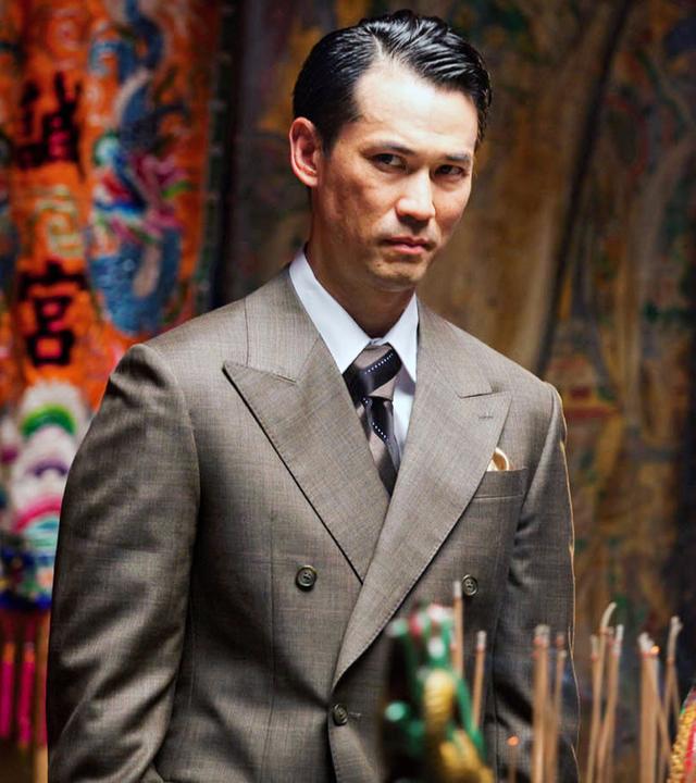 Asiate im Anzug mit skeptischen Blick