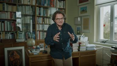 Der Kunstwissenschaftler und Kurator Paul Kaiser gestikulierend in Bücherstube