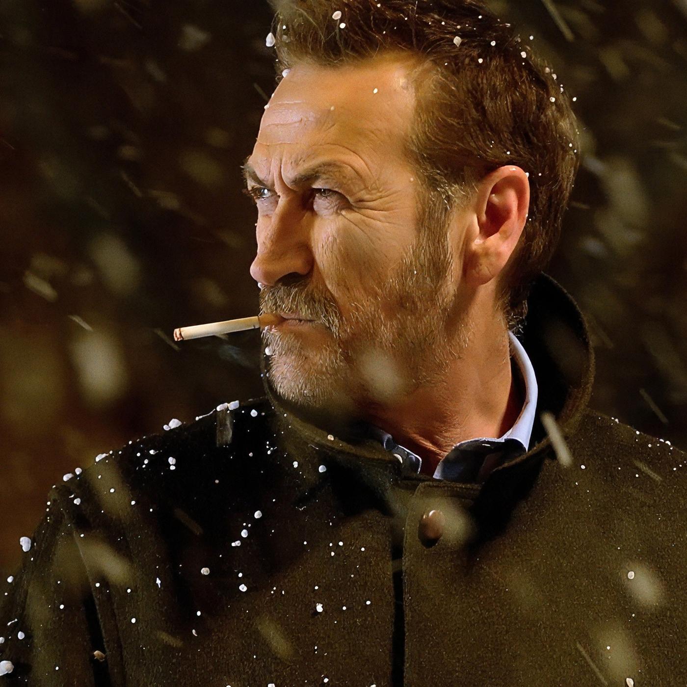 Kommissar Rocco Schiavone (Mario Giallini) steht mit einer Zigarette im Mund im Schneefall