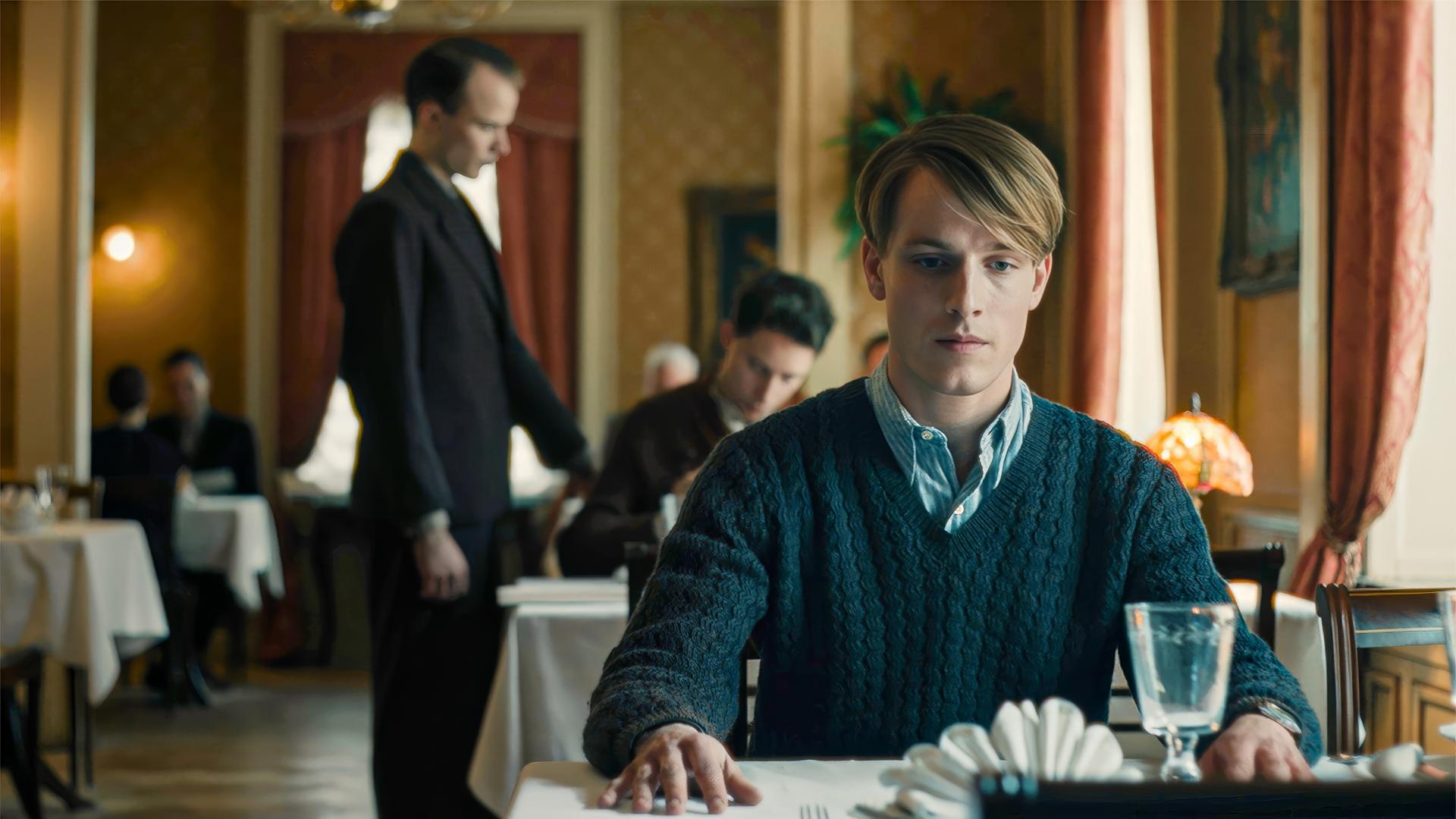 Junger Mann sitzt in einem Restaurant am Tisch.