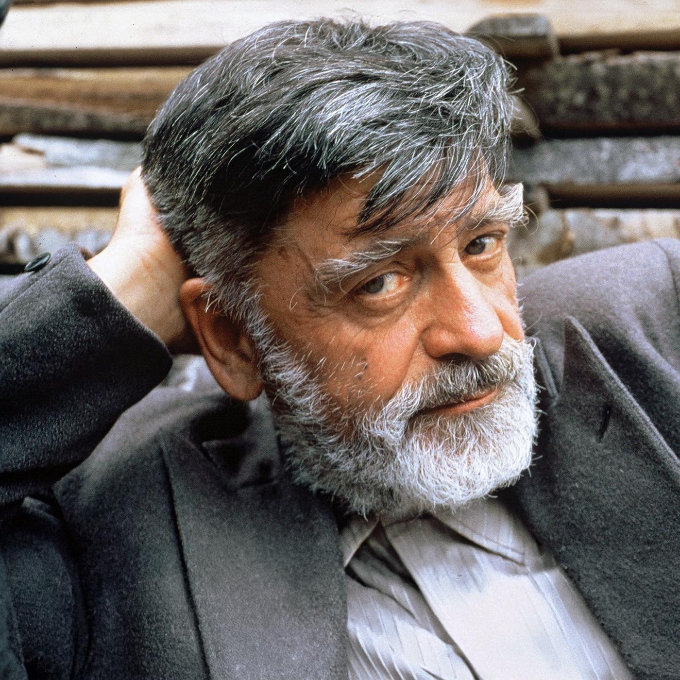 Otto Mächtlinger als Kaspar Tanner mit grauem Haar und Bart in Nahaufnahme, die Hand hinter dem Kopf.