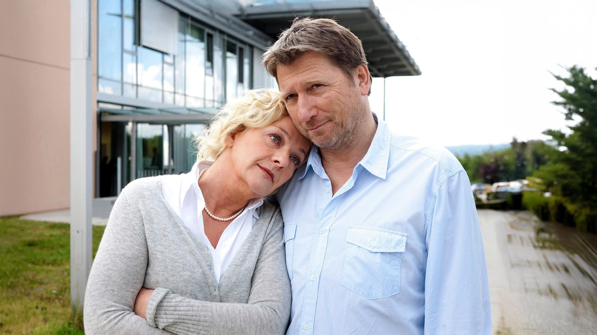 Eine Frau lehnt sich an die Seite eines Mannes.