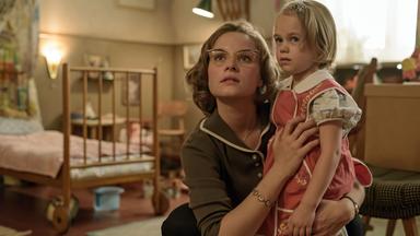 Monika Schöllack (Sonja Gerhardt, l.) hat ihre Tochter Dorli (Alma / Smilla Löhr, r.) im Arm. Im Hintergrund ist ein Kinderzimmer zu sehen.