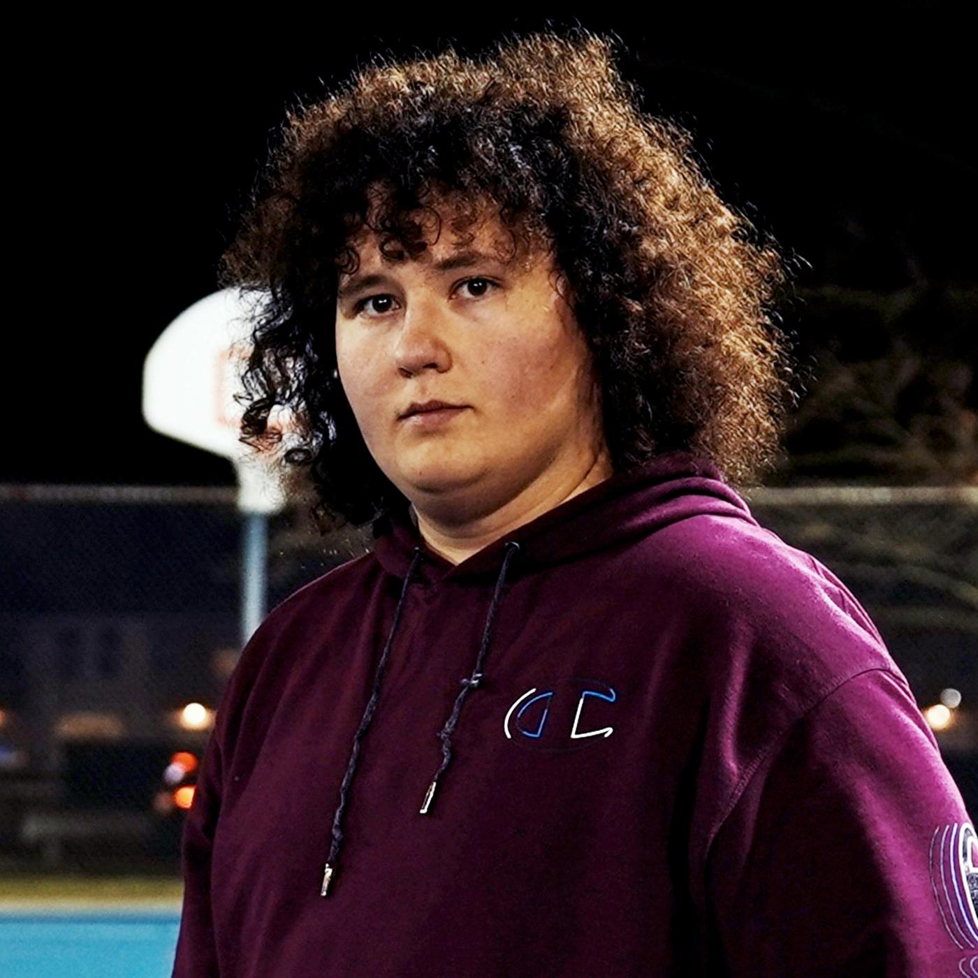 Ein junger Mann mit lockigem Haar.