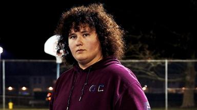 Ein junger Mann mit lockigem Haar.