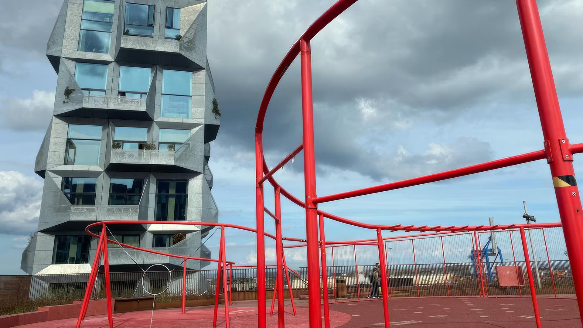 Ein modernes Hochhaus und ein Spielplatz.