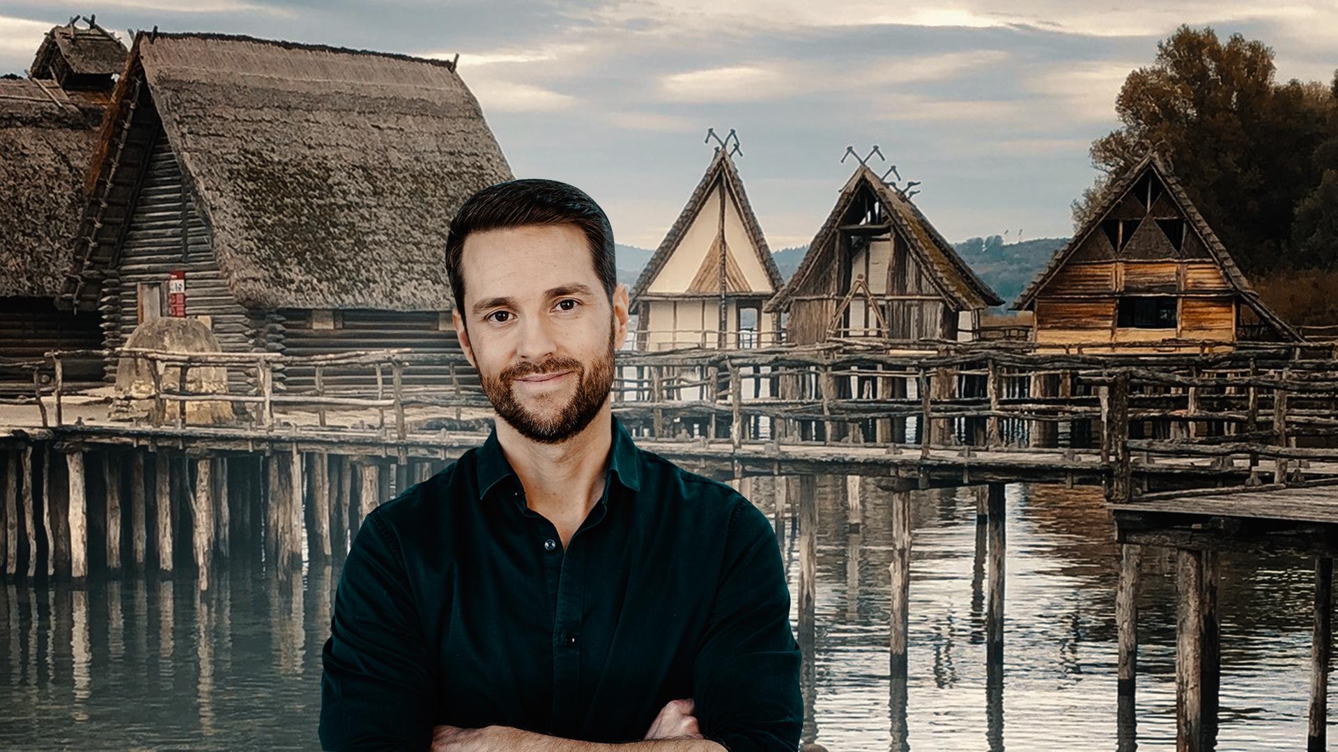 Mirko Drotschmann steht vor einem Dorf auf Stelzen