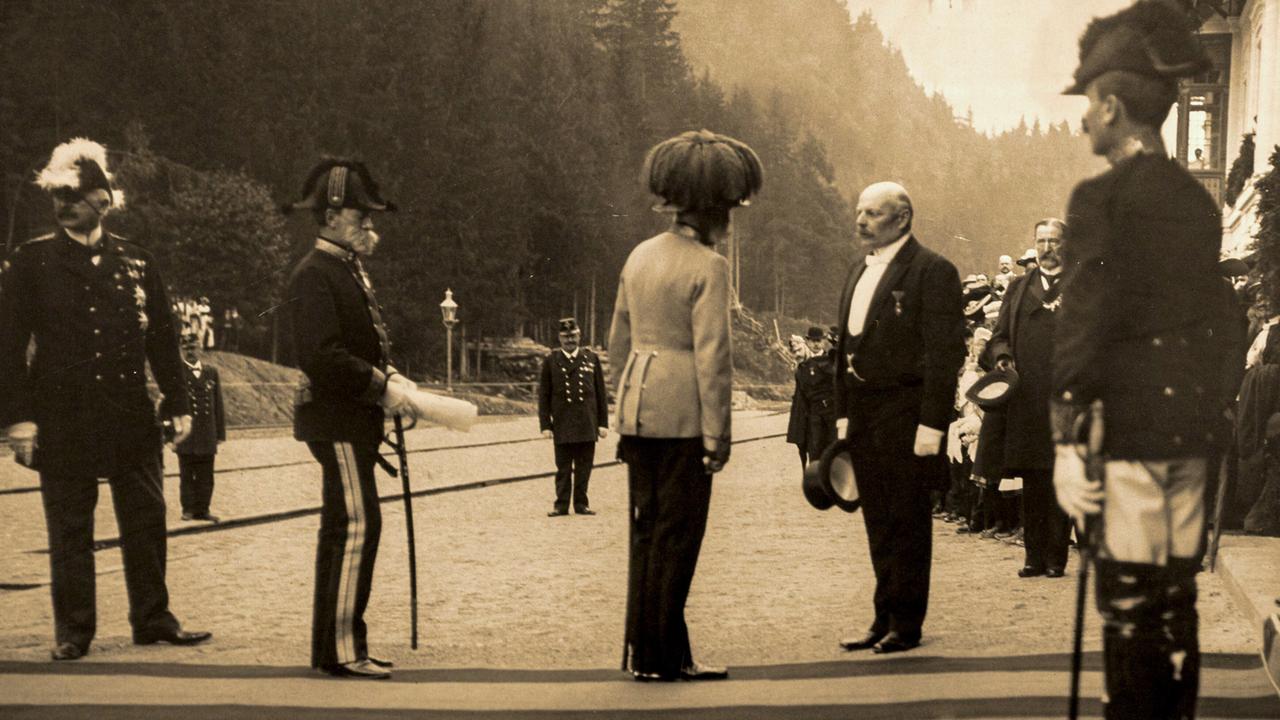 Historische Aufnahme: Männer in Uniformen begrüßen den Kaiser