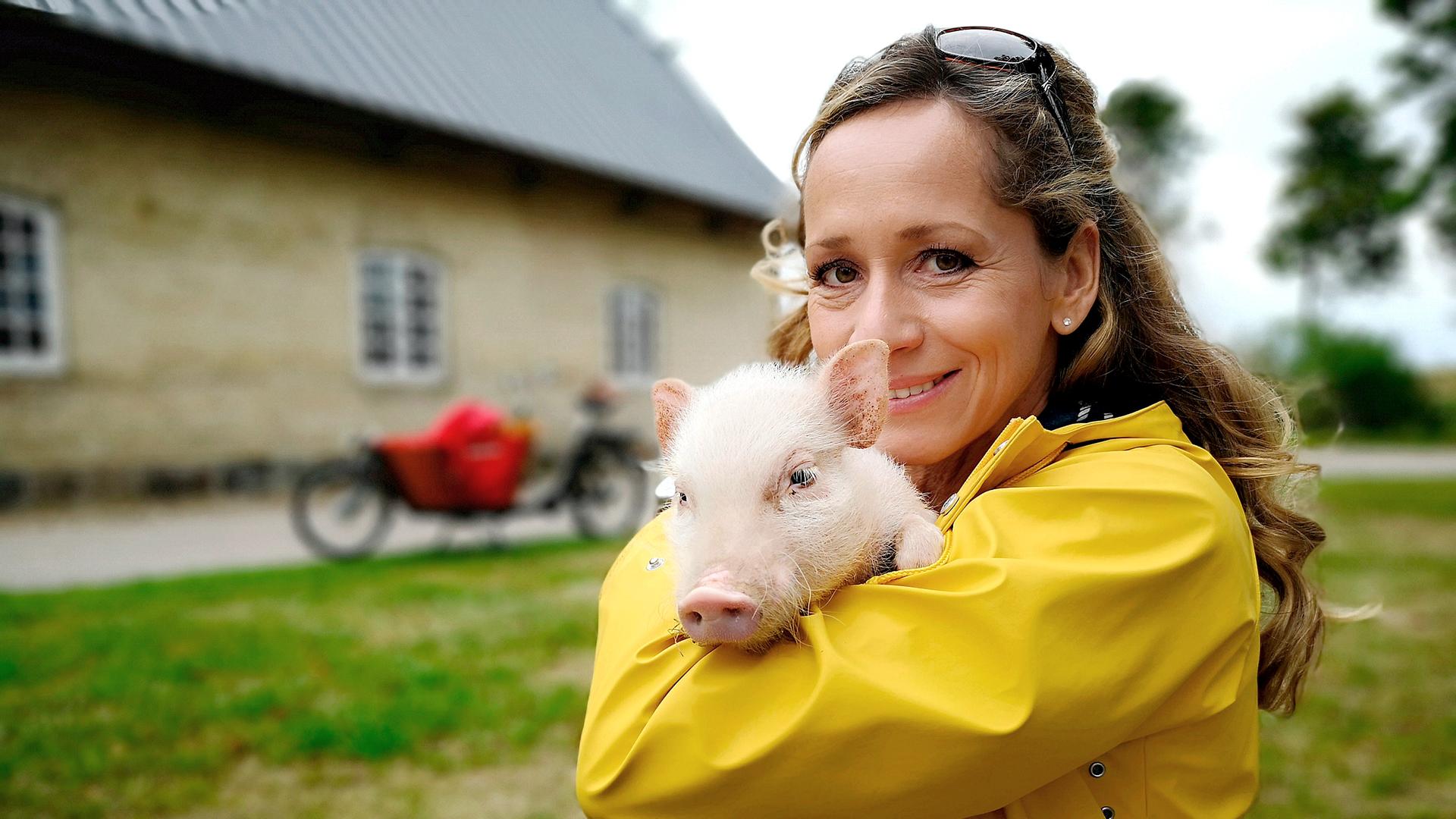 Moderatorin Tamina Kallert hält ein kleines Ferkel auf dem Arm
