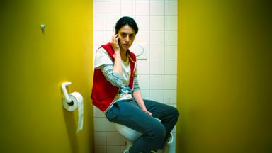 „Die Hölle“: Özge (Violetta Schurawlow) befindet sich in einer Toiletten-Kabine und telefoniert.