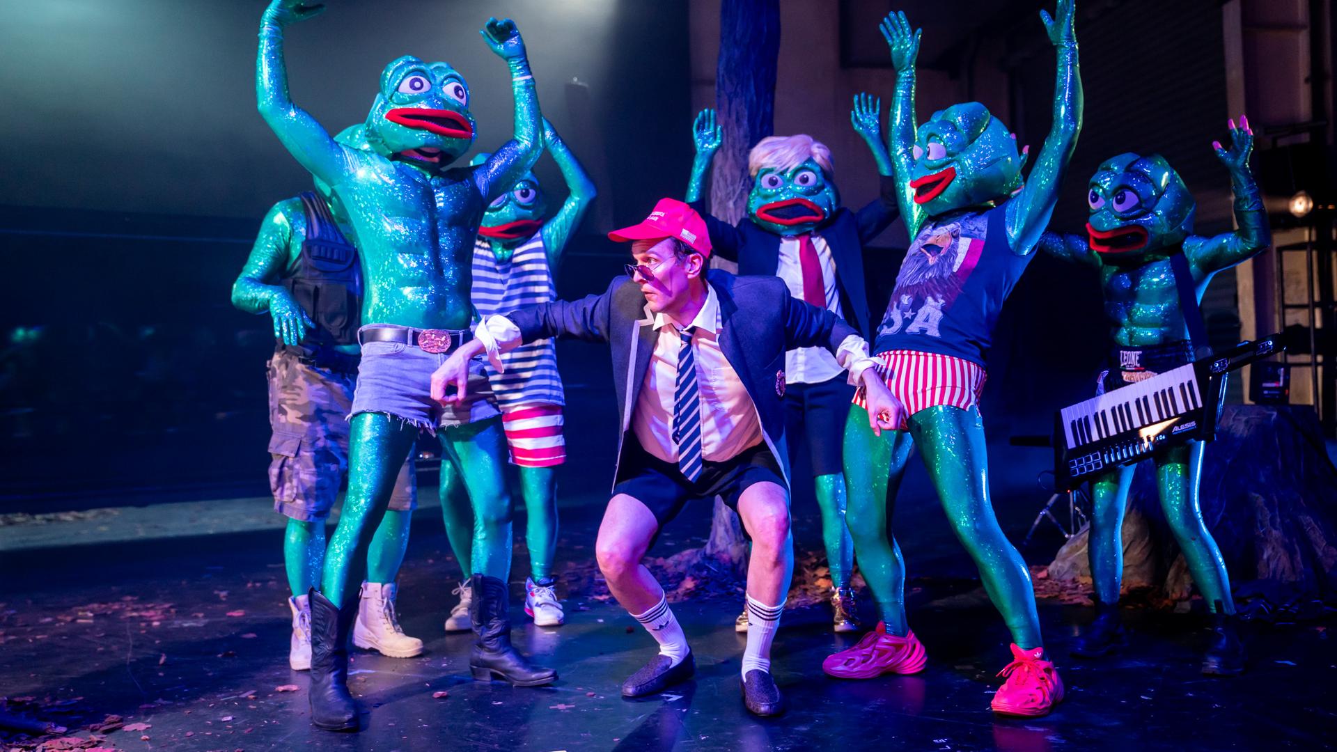 Männer halten Baumstamm auf der Bühne in ihren Armen.