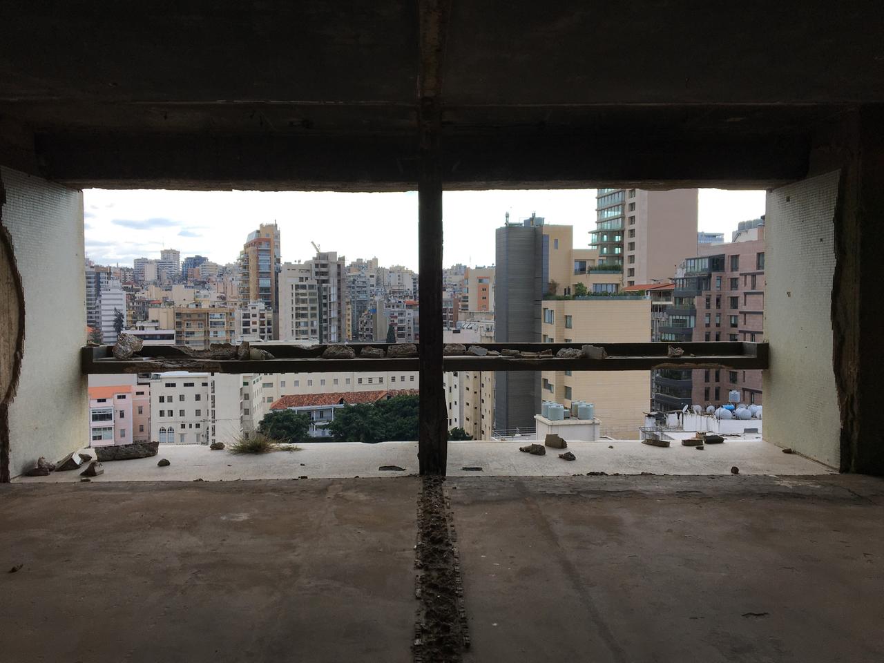 Blick aus einem zerstörten Fenster auf Skyline Beirut