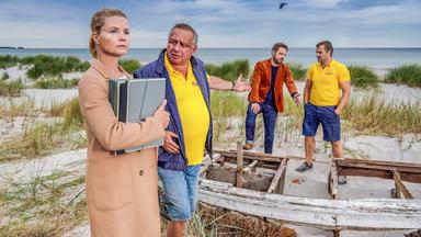 "Ella Schön - Die nackte Wahrheit": Ella steht im Bildvordergrund mit ihrem Klienten Holger Packebusch (Hilmar Eichhorn). Hinten unterhalten sich seine Söhne Maik (Stefan Rudolf) und Kurt (Christoph Letkowski).