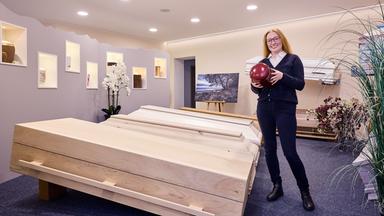 May Hansen (23) wurde 2025 zur besten Bestatterin Deutschlands gekürt, hier zu sehen neben Holzsärgen