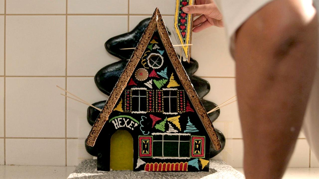 Martin Kotzsch stabilisert das Dach seines Pefferkuchenhäuschens mit Hozstäbchen.