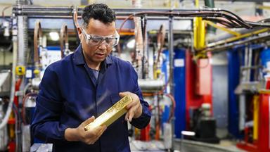 Ein Mann hält einen Goldbarren in den Händen. Der Barren hat einen geschätzten Wert von über 900.000 Euro.