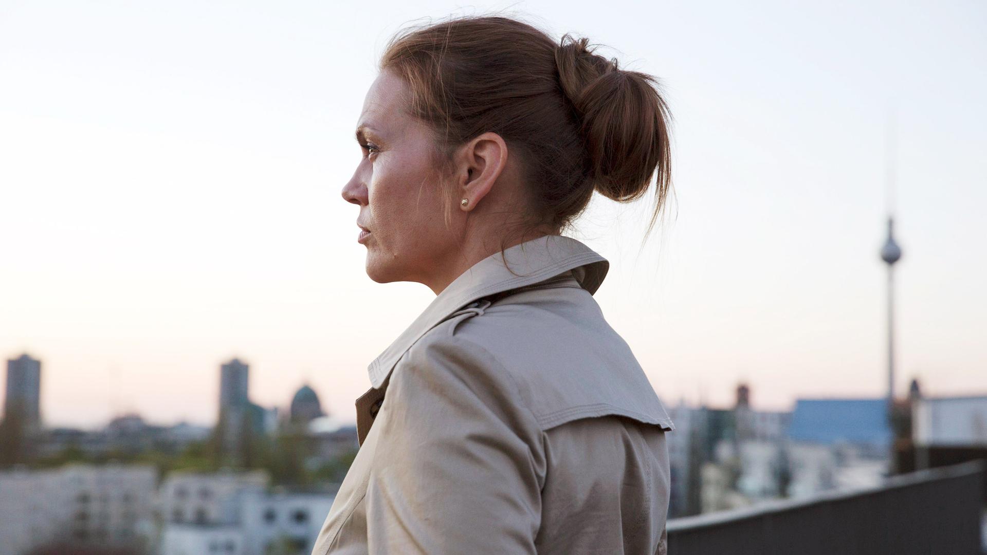 Susanne Kröhmer (Anna Loos) steht auf der Dachterasse und blickt über die Berlin.