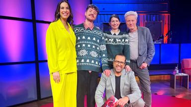 Zwei Frauen und drei Männer auf einer pink-blau beleuchteten Bühne