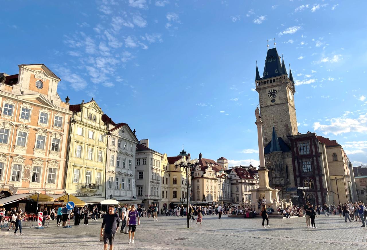 Belebter Platz mit historischen Fassaden und Kirche