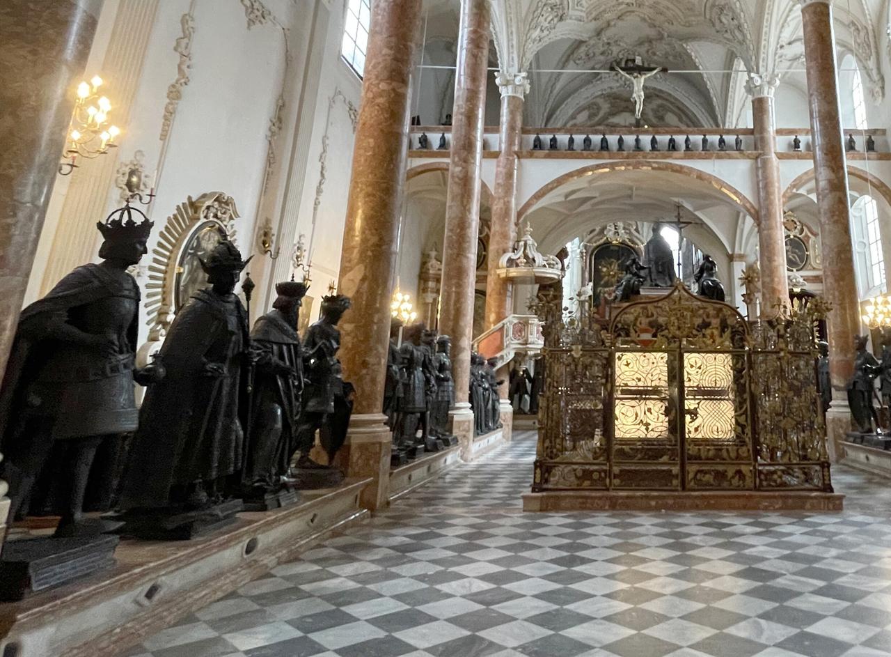 Innenraum einer großen Kirche, rechts und links schwarze Statuen