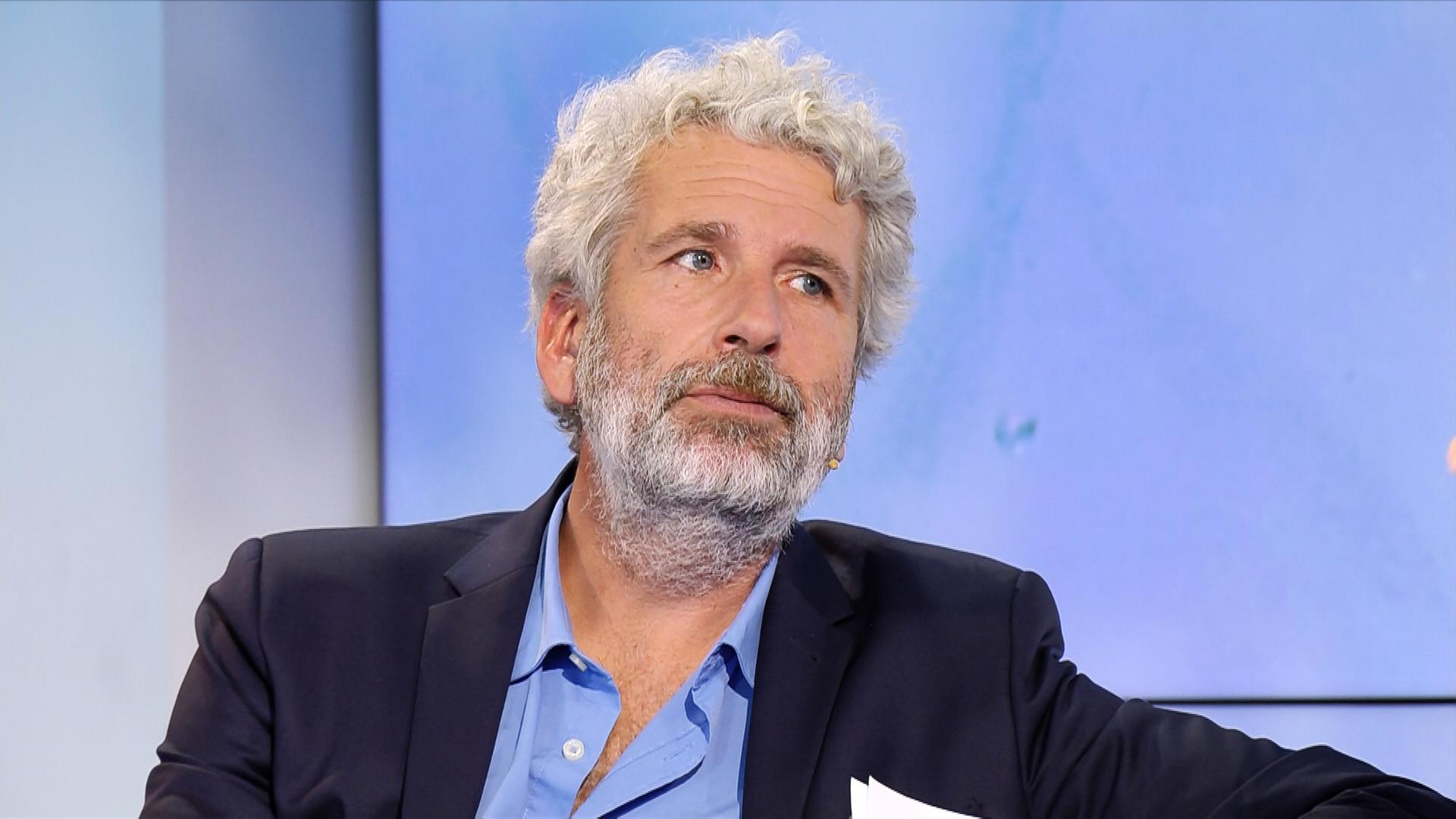 Der Schriftsteller Dirk Stermann - Mann mit gelockten grauen Haaren und Bart.