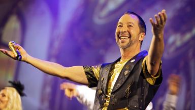 DJ Bobo steht mit ausgebreiteten Armen auf der Bühne.