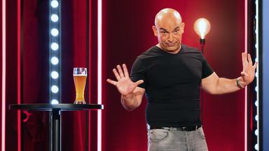 Django Asül auf einer Bühne.