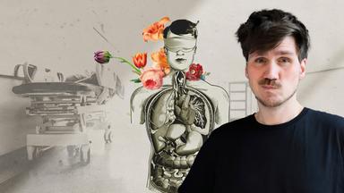 Frank Seibert in schwarzem T-Shirt vor Grafik, die einen transparenten Korpus zeigt. Die inneren Organe werden sichtbar, der Korpus hat bunten Blumen in der Kopfregion.