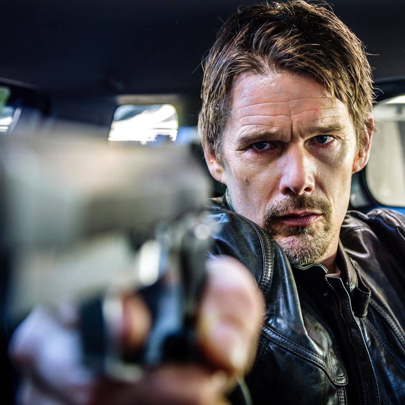 Travis Conrad (Ethan Hawke) sitzt in einem Auto und zielt mit einer Pistole aus dem Seitenfenster.