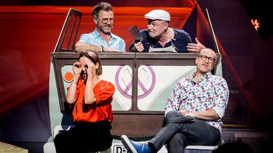 Das Ensemble des Düsseldorfer Kom(m)ödchens ist auf der Bühne zu sehen. Im Hintergrund ist ein Bus. Die Bühne ist rot beleuchtet.