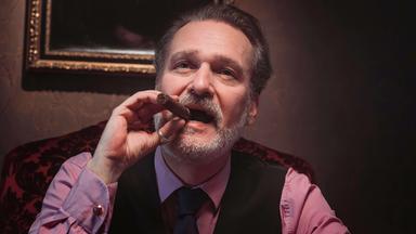 Ein Mann raucht Zigarre.