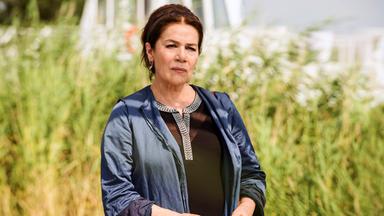 Eine Frau in einer blauen Jacke schaut kritisch nach vorn